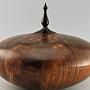 This hollow form is made from a splendid piece of Walnut, from the crotch of the tree. It is about 9" wide and 7" tall to the top of the ebony finial.